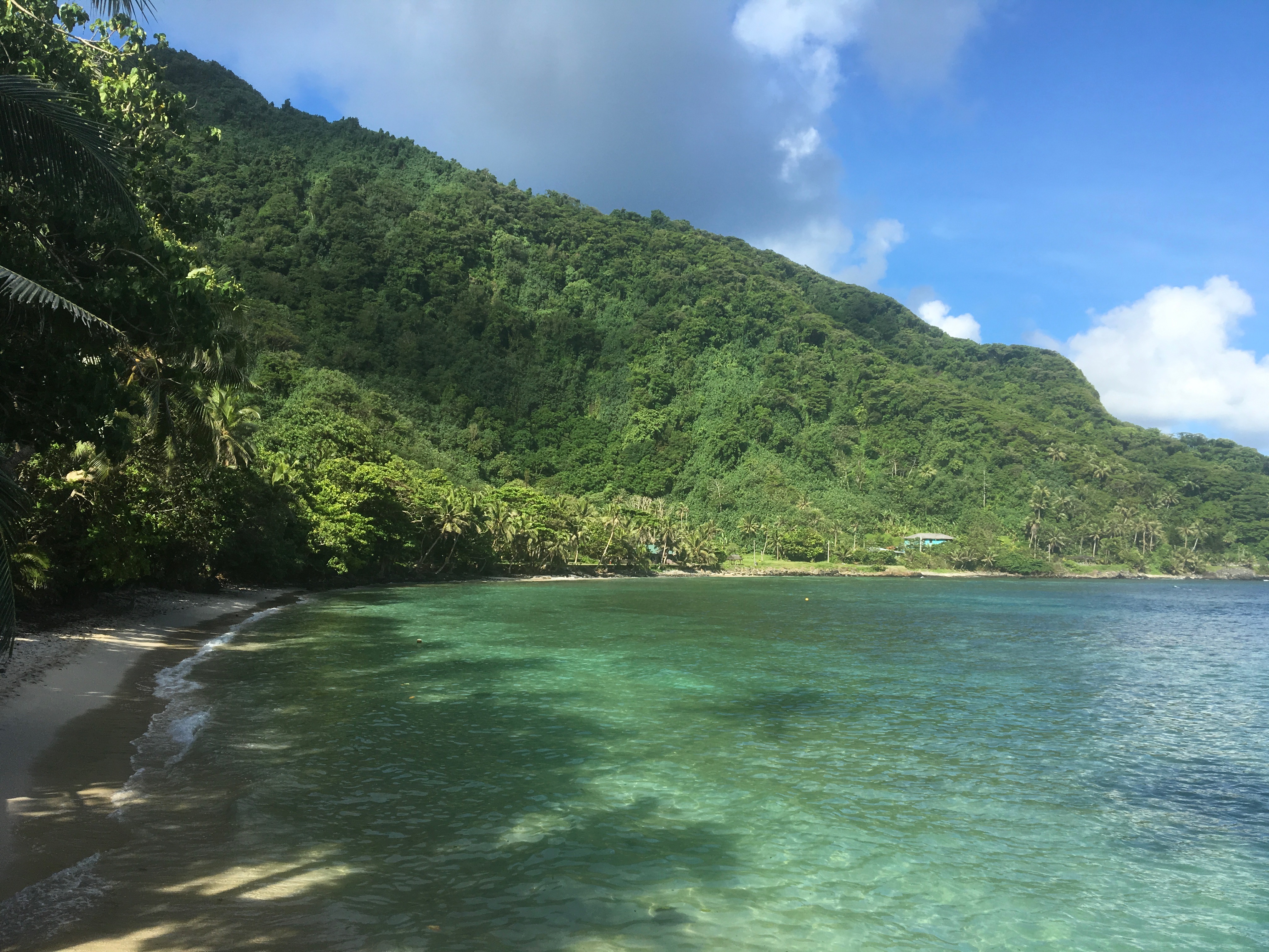Beautiful Alega Bay coastline with turquoise water and lush green hills
